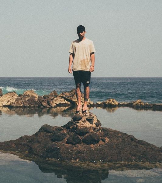 Man standing on rocks on Island, INMIND x Hands For Feet