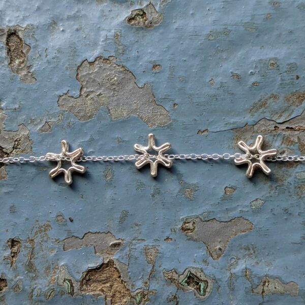 Three tiny fine silver flowers, handmade from recycled fine silver on a recycled sterling silver chain.